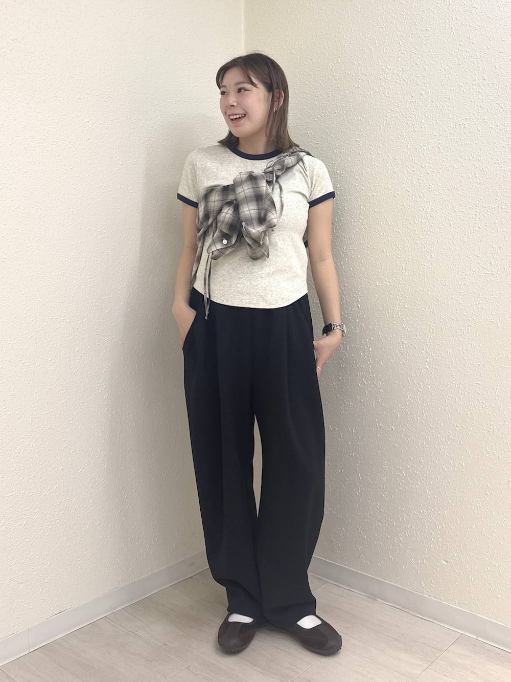 ブラック系のスウェットパンツ、ブラウン系のスニーカー、グレー系のTシャツ/カットソーを着用したレディースの春コーディネートの2枚目の写真
