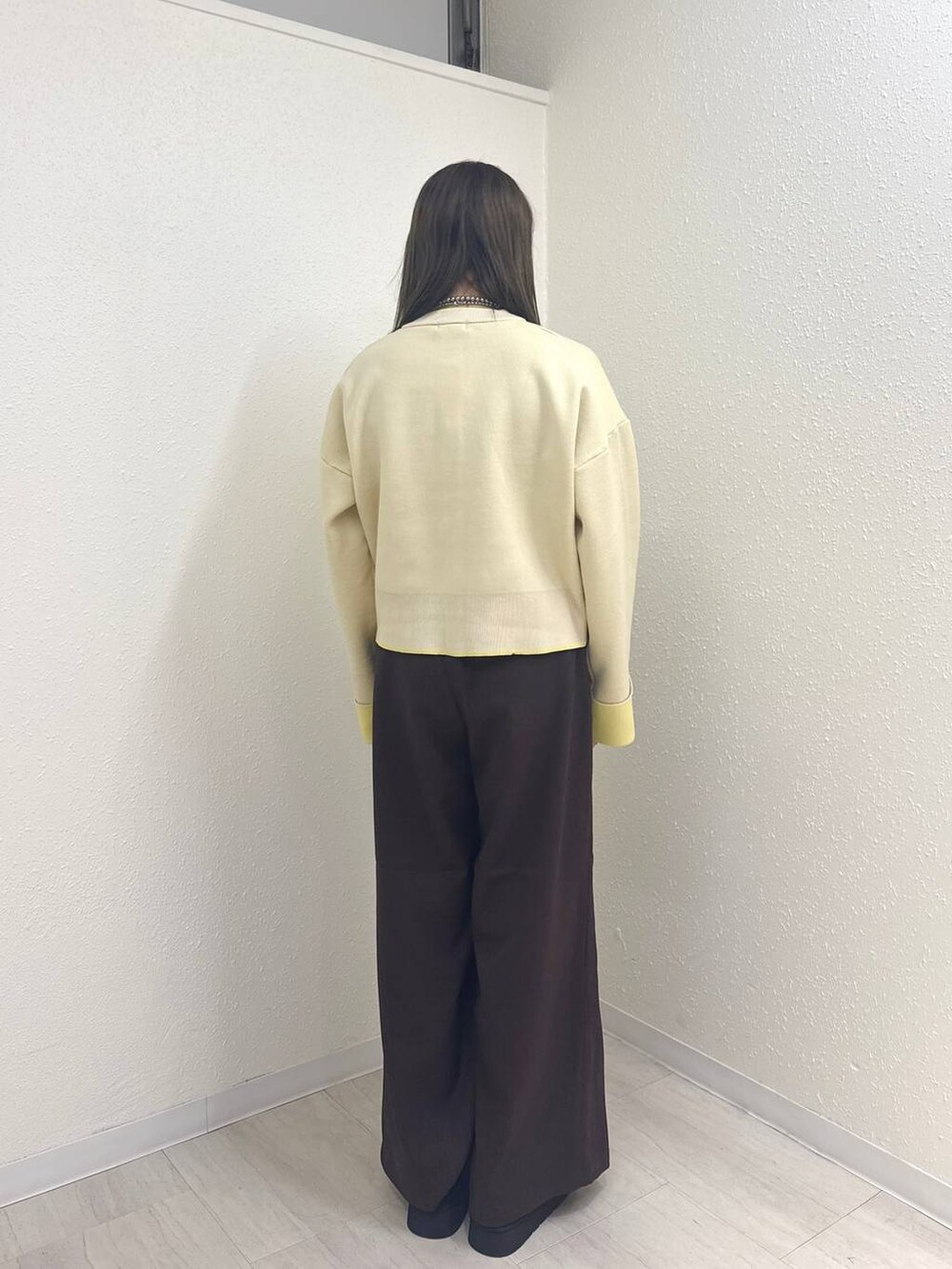 ブラウン系のその他パンツ、ブラック系のブーツ、ホワイト系のカーディガン/ボレロを着用したレディースの冬コーディネートの3枚目の写真