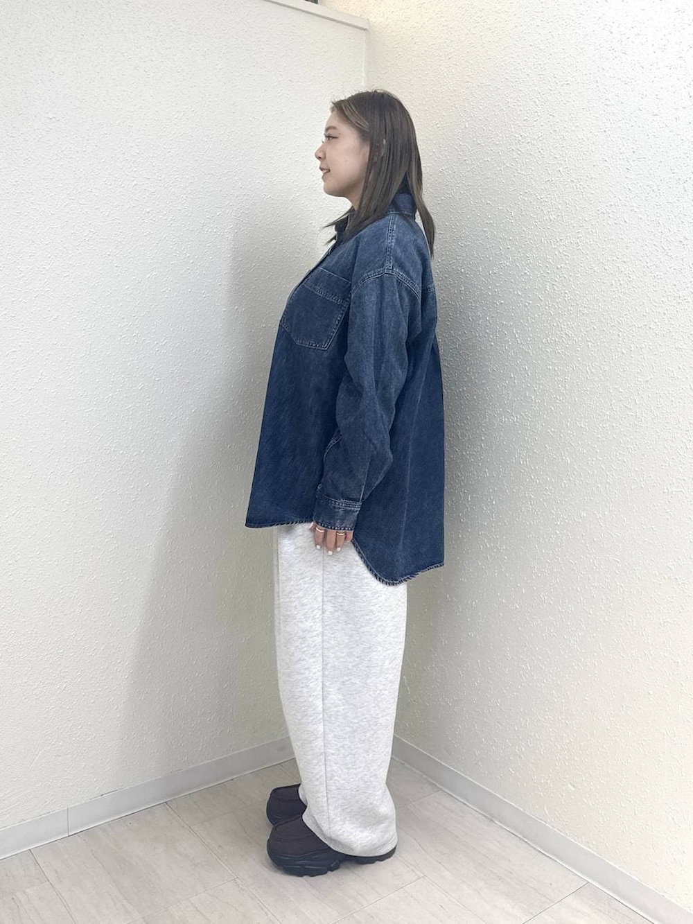 グレー系のスウェットパンツ、ブルー系のシャツ/ブラウス、ブラウン系のローファーを着用したレディースの冬コーディネートの3枚目の写真