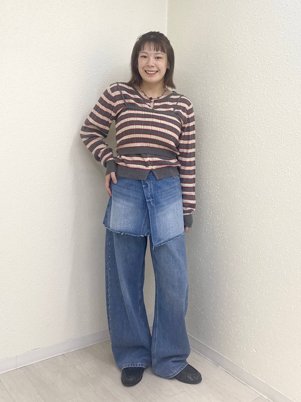 ブルー系のデニムパンツ、ブラック系のローファー、ブルー系のデニムパンツを着用したレディースの秋コーディネートの3枚目の写真