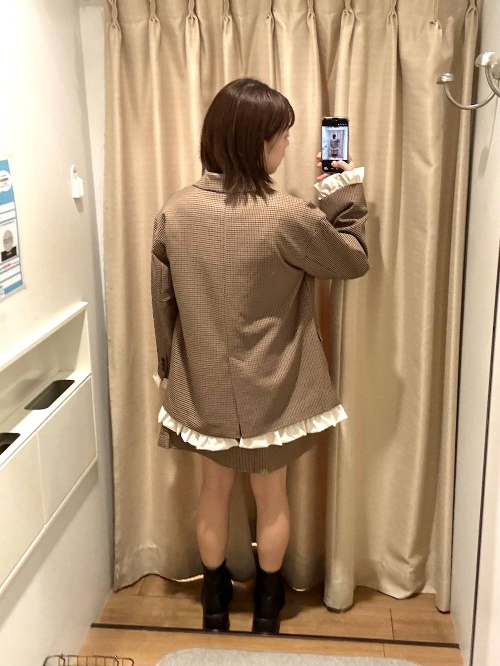 ブラック系のブーツ、ホワイト系のTシャツ/カットソー、ブラウン系のテーラードジャケットを着用したレディースの秋コーディネートの3枚目の写真