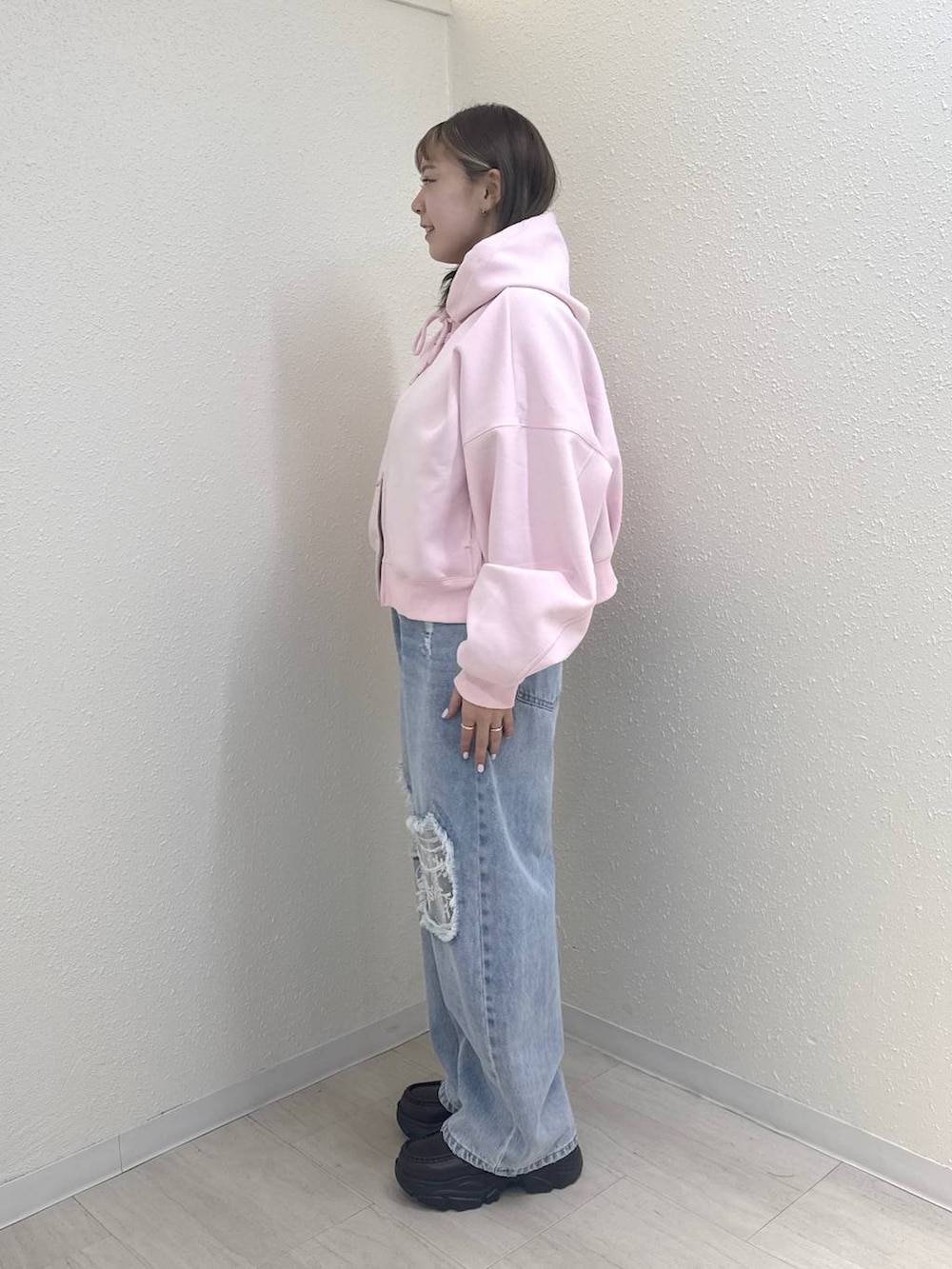 ピンク系のパーカー、ブルー系のデニムパンツ、ブラウン系のローファーを着用したレディースの冬コーディネートの2枚目の写真