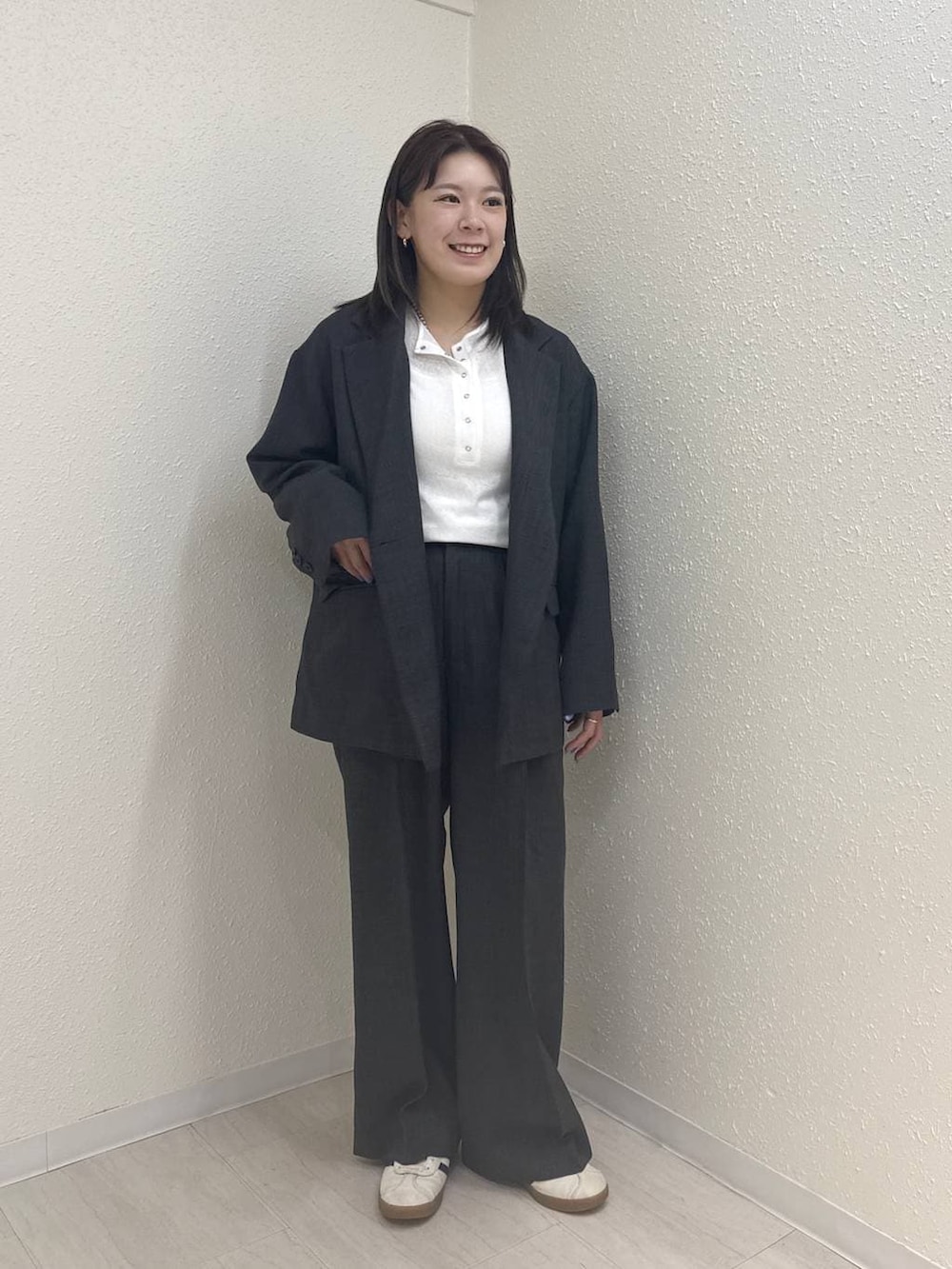 グレー系のテーラードジャケット、グレー系のデニムパンツ、ホワイト系のTシャツ/カットソーを着用したレディースの春コーディネートの2枚目の写真