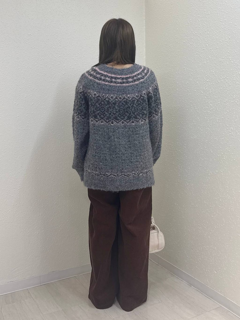 ブラウン系のその他パンツ、ブラック系のモカシン/デッキシューズ、ホワイト系のボストンバッグを着用したレディースの冬コーディネートの3枚目の写真