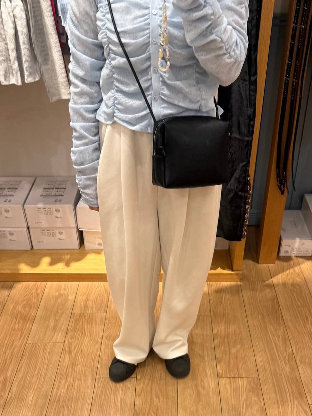 ベージュ系のスウェットパンツ、ブルー系のカーディガン/ボレロ、ブラック系のトートバッグを着用したレディースの春コーディネートの3枚目の写真