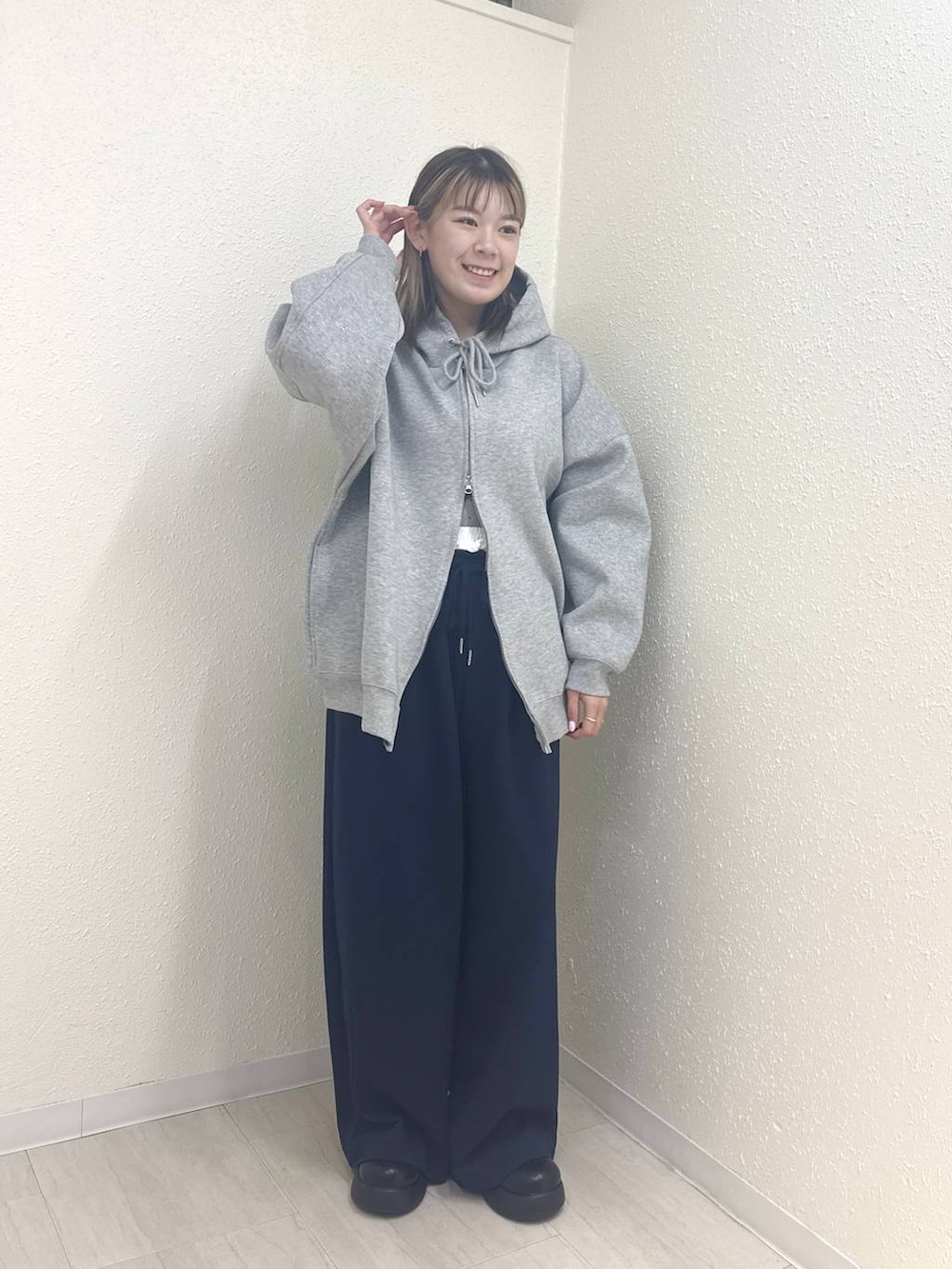 グレー系のパーカー、ブラック系のサンダル、ブルー系のスウェットパンツを着用したレディースの冬コーディネートの2枚目の写真