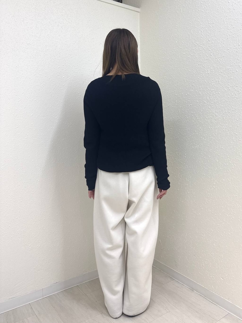 ベージュ系のスウェットパンツ、ブラック系のニット/セーター、ブラック系のTシャツ/カットソーを着用したレディースの春コーディネートの4枚目の写真