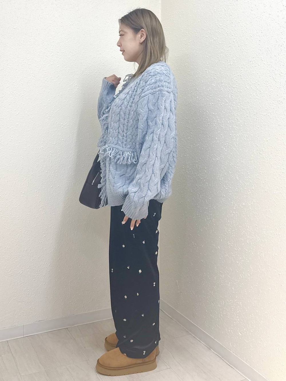 ベージュ系のブーツ、ブルー系のニット/セーター、ブラウン系のボストンバッグを着用したレディースの秋コーディネートの2枚目の写真