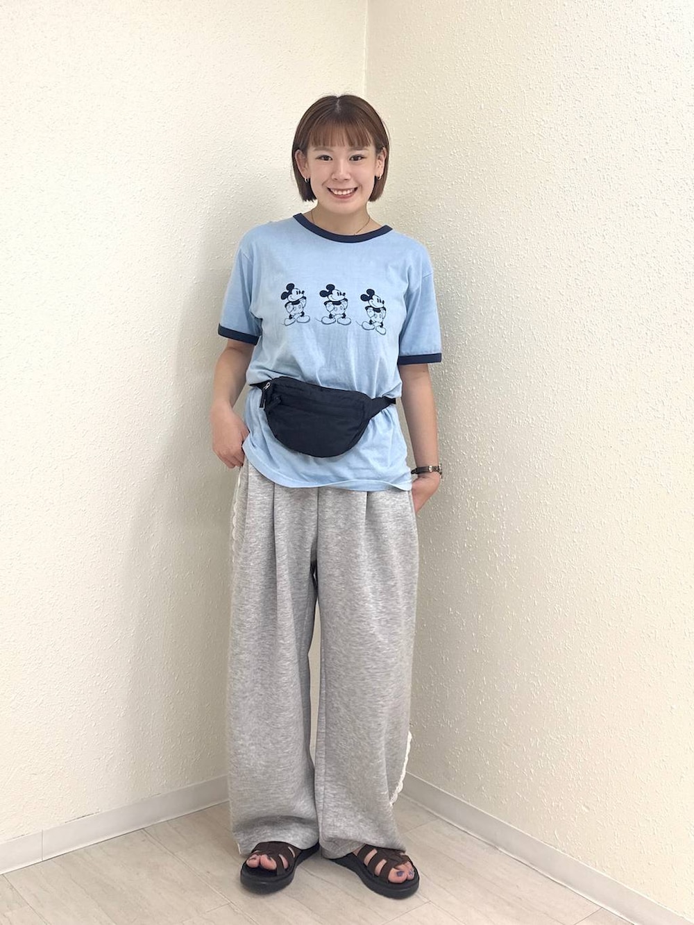 グレー系のスウェットパンツ、ブラック系のボディバッグ/ウエストポーチ、ブラウン系のサンダルを着用したレディースの夏コーディネートの2枚目の写真