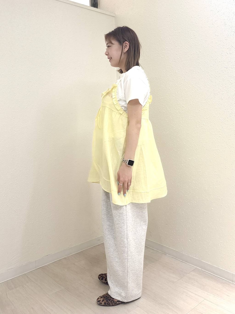 グレー系のスウェットパンツ、ホワイト系のTシャツ/カットソー、イエロー系のキャミソールを着用したレディースの春コーディネートの3枚目の写真