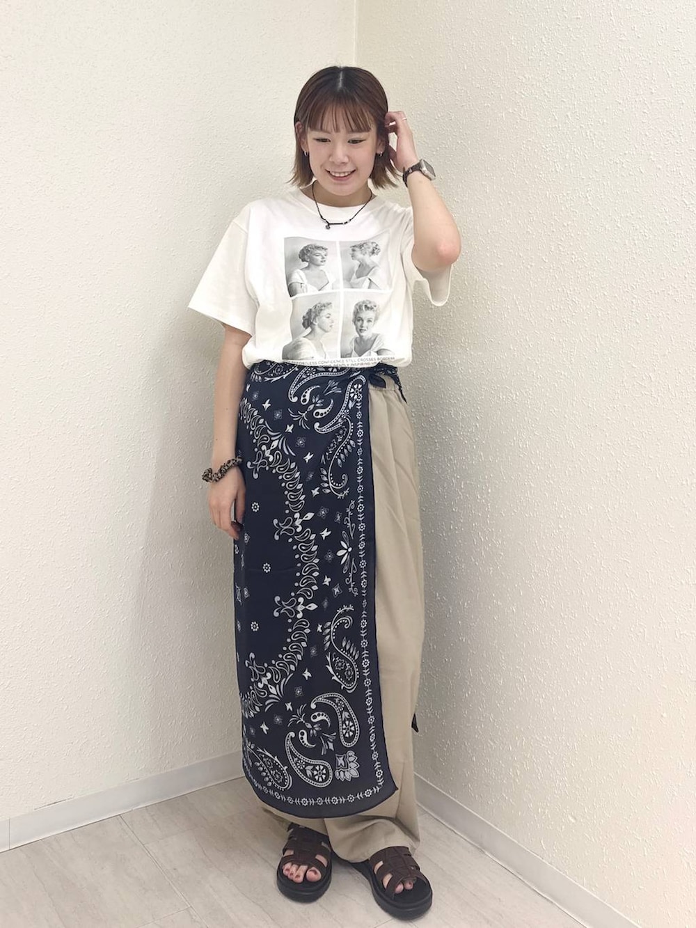 ベージュ系のその他パンツ、ブラウン系のサンダル、ホワイト系のTシャツ/カットソーを着用したレディースの夏コーディネートの3枚目の写真