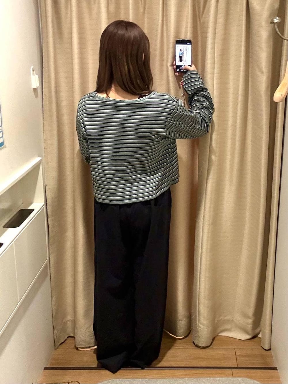 ブラック系のデニムパンツ、グリーン系のカーディガン/ボレロを着用したレディースの春コーディネートの3枚目の写真