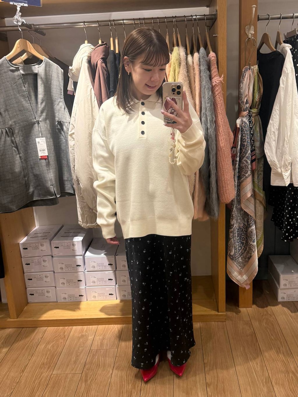 ブラック系のスカート、レッド系のパンプス、ホワイト系のニット/セーターを着用したレディースの冬コーディネートの2枚目の写真