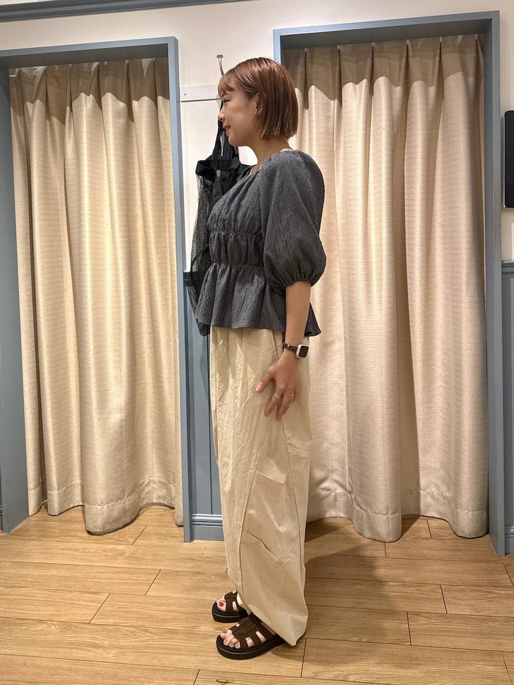 ベージュ系のその他パンツ、ブラウン系のサンダル、グレー系のシャツ/ブラウスを着用したレディースの夏コーディネートの2枚目の写真