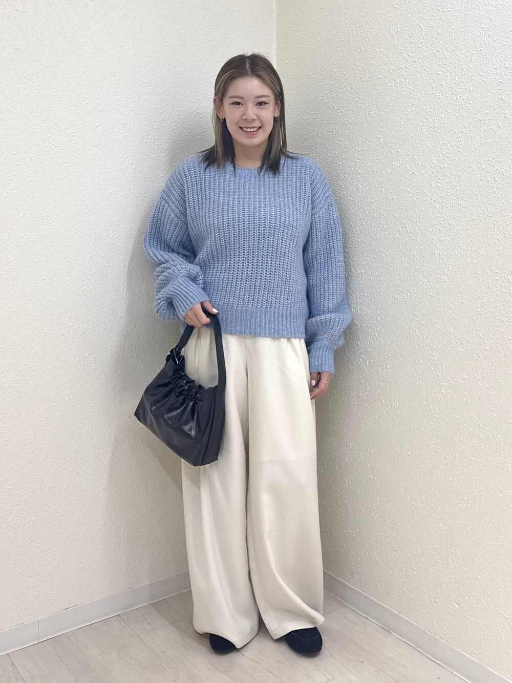 ホワイト系のその他パンツ、ブルー系のニット/セーター、ブラック系のショルダーバッグを着用したレディースの冬コーディネートの3枚目の写真