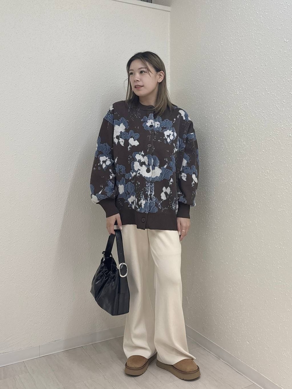 ホワイト系のその他パンツ、ベージュ系のブーツ、ブラウン系のカーディガン/ボレロを着用したレディースの冬コーディネートの2枚目の写真