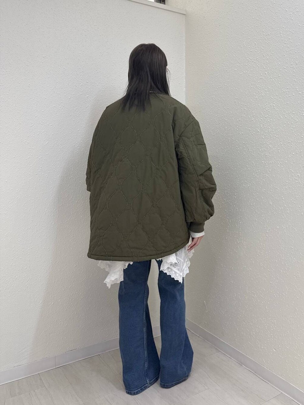 ブルー系のデニムパンツ、ホワイト系のスカート、ブラウン系のモカシン/デッキシューズを着用したレディースの冬コーディネートの4枚目の写真