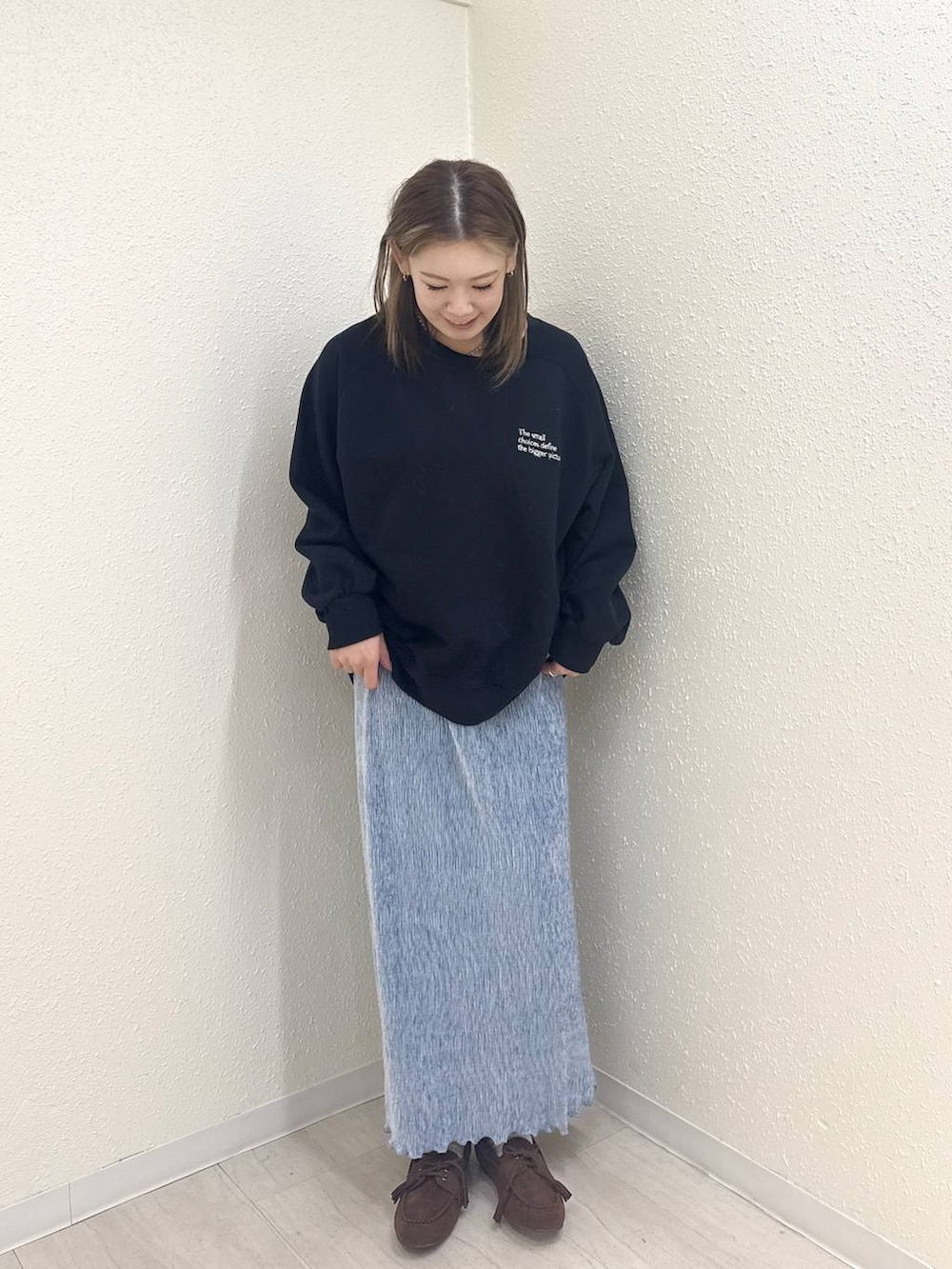 ブルー系のスカート、ブラック系のモカシン/デッキシューズ、ブラック系のスウェットを着用したレディースの冬コーディネートの2枚目の写真