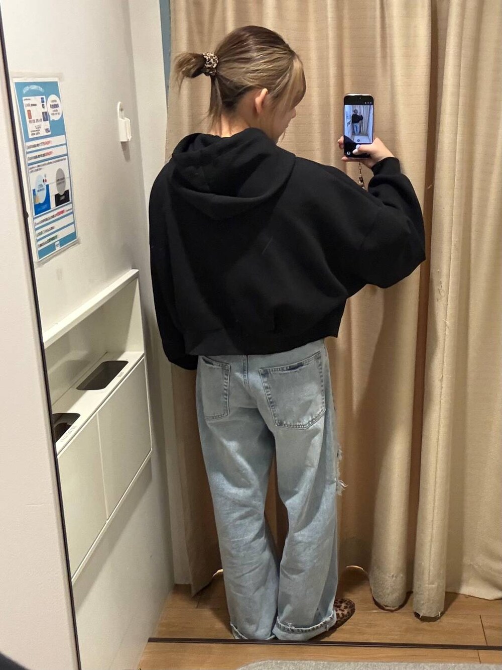 ブラック系のパーカー、ブルー系のデニムパンツ、イエロー系のTシャツ/カットソーを着用したレディースの冬コーディネートの2枚目の写真