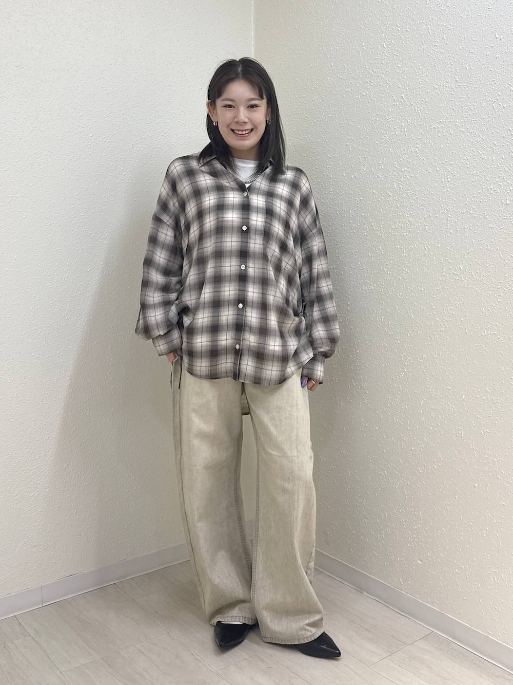 ホワイト系のTシャツ/カットソー、ブラック系のパンプス、ベージュ系のデニムパンツを着用したレディースの春コーディネートの2枚目の写真