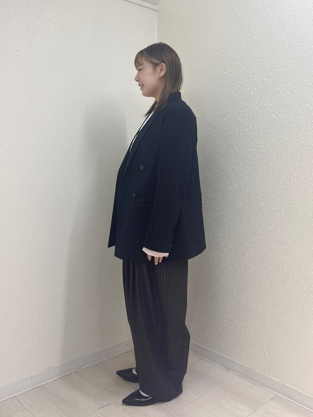 ブルー系のその他パンツ、ブラック系のパンプス、ブラック系のテーラードジャケットを着用したレディースの冬コーディネートの2枚目の写真