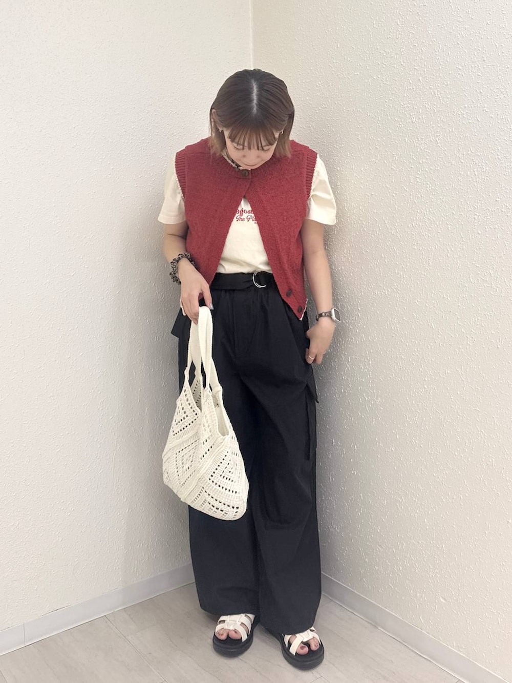 ホワイト系のサンダル、レッド系のベスト、ブラック系のカーゴパンツを着用したレディースの夏コーディネートの2枚目の写真