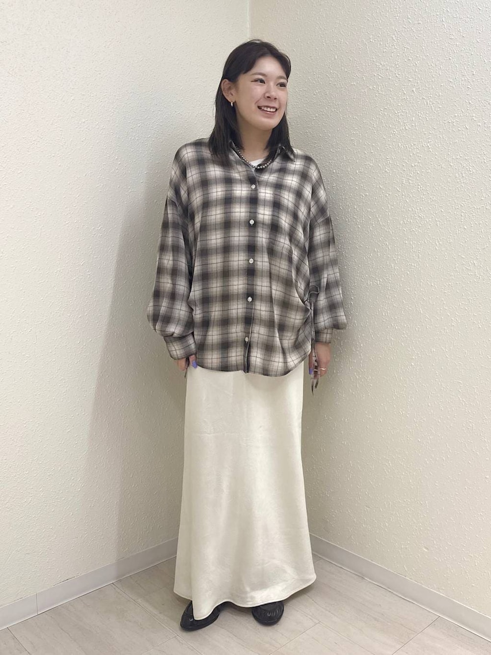 ホワイト系のスカート、ブラック系のローファー、ブラウン系のシャツ/ブラウスを着用したレディースの春コーディネートの2枚目の写真