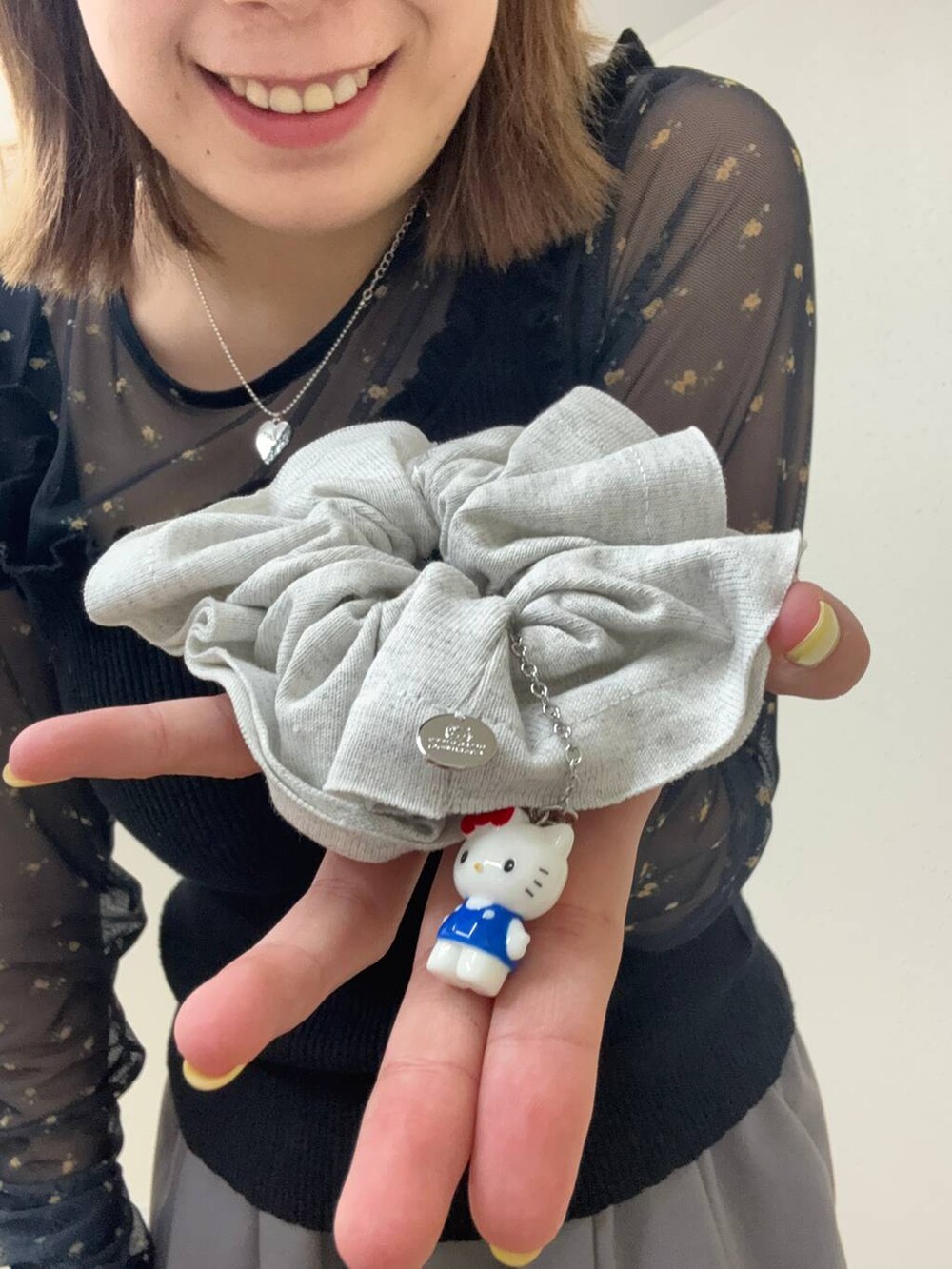 グレー系のシュシュ、ブラウン系のシュシュを着用したレディースの春コーディネートの2枚目の写真