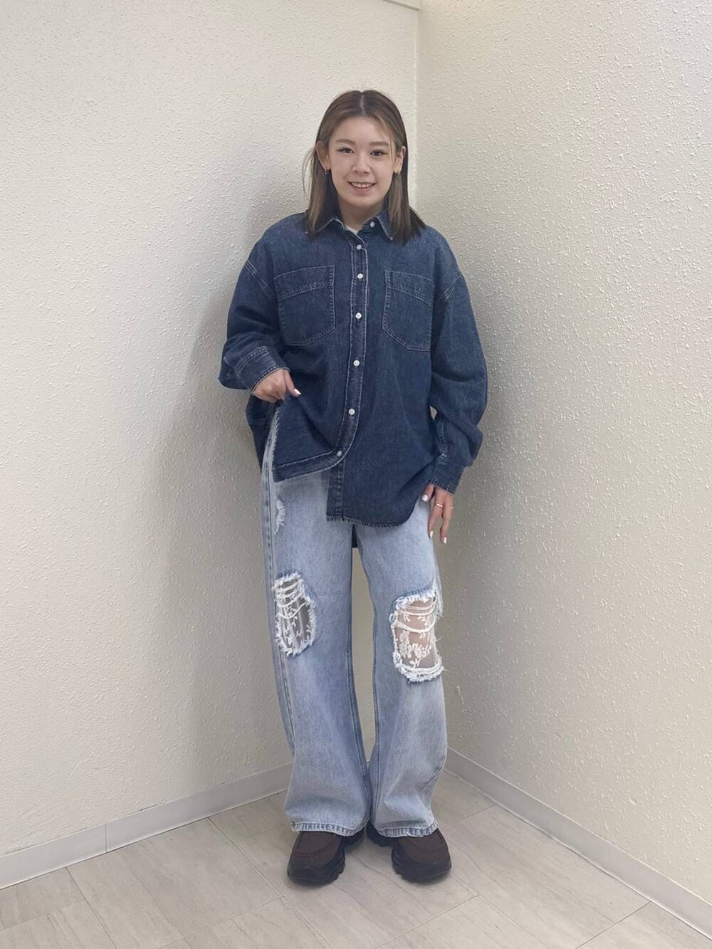 ブルー系のデニムパンツ、ブルー系のシャツ/ブラウス、ブラウン系のローファーを着用したレディースの冬コーディネートの2枚目の写真