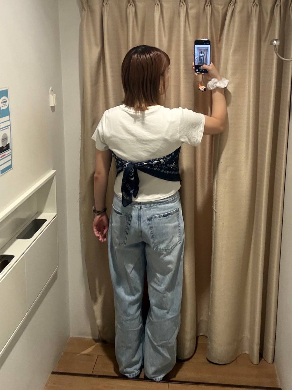 ブルー系のデニムパンツ、ホワイト系のTシャツ/カットソー、ブラウン系のサンダルを着用したレディースの夏コーディネートの2枚目の写真