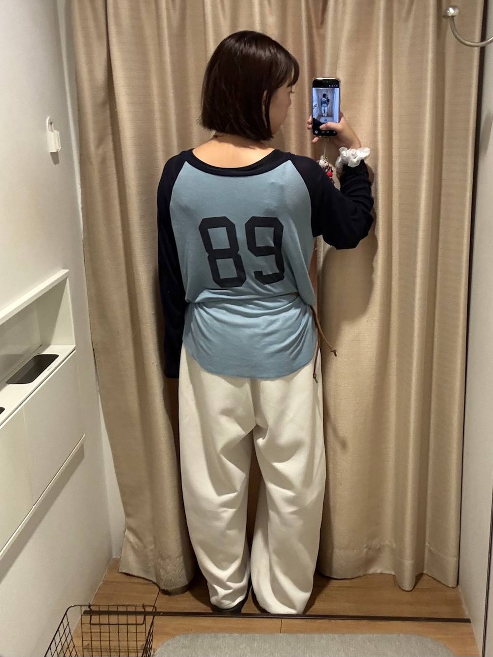 イエロー系のボディバッグ/ウエストポーチ、ブルー系のTシャツ/カットソー、ベージュ系のスウェットパンツを着用したレディースの夏コーディネートの2枚目の写真