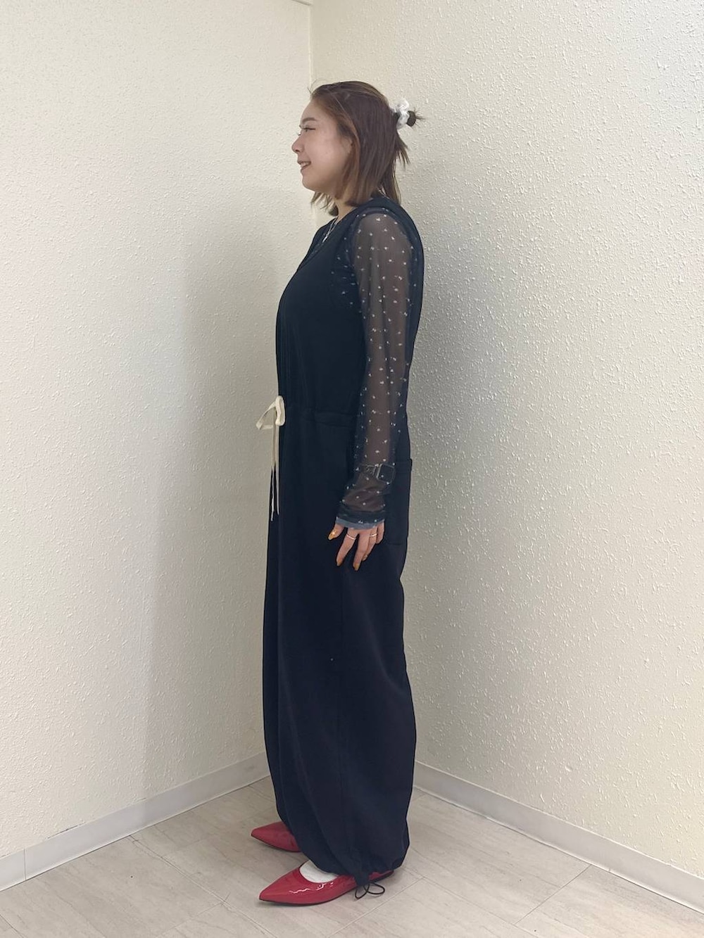 レッド系のパンプス、ブルー系のTシャツ/カットソー、ブラック系のサロペット/オーバーオールを着用したレディースの春コーディネートの3枚目の写真