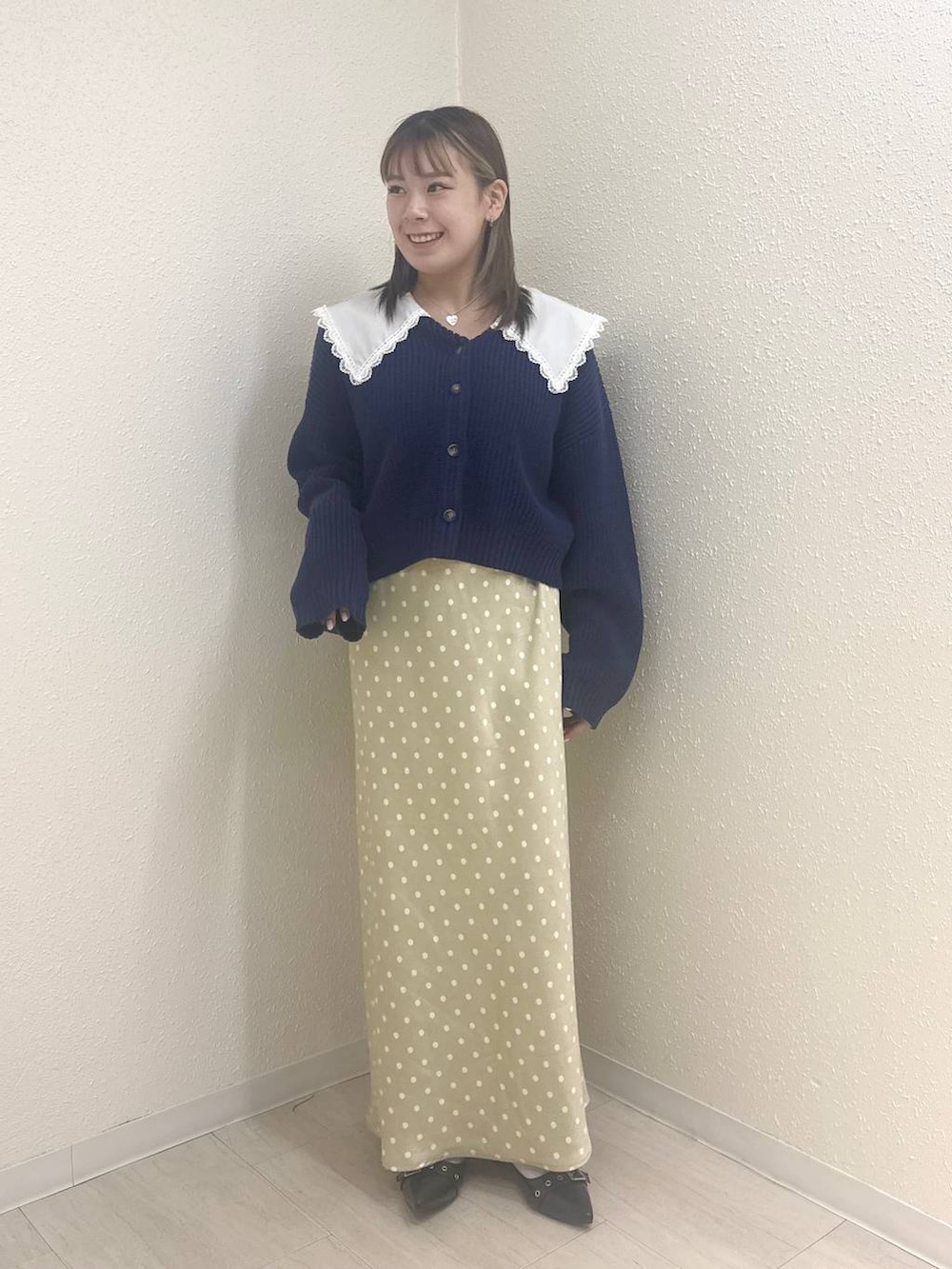 ベージュ系のスカート、ブルー系のカーディガン/ボレロを着用したレディースの冬コーディネートの2枚目の写真