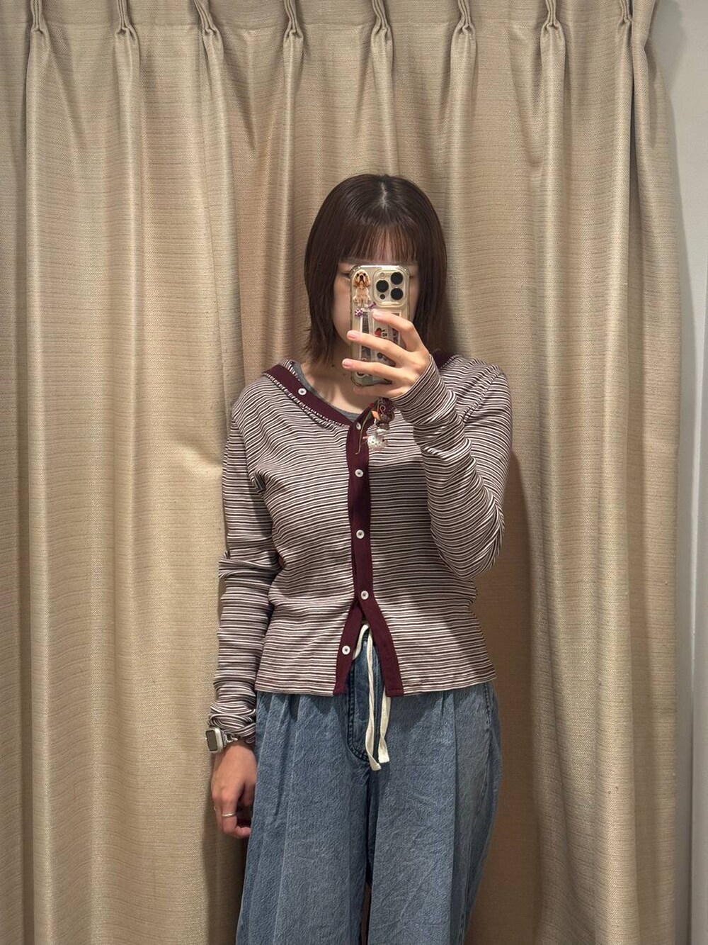 レッド系のカーディガン/ボレロ、ブルー系のデニムパンツを着用したレディースの秋コーディネートの3枚目の写真