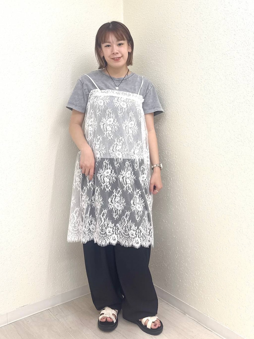 ブラック系のその他パンツ、ホワイト系のサンダル、ホワイト系のワンピースを着用したレディースの春コーディネートの4枚目の写真