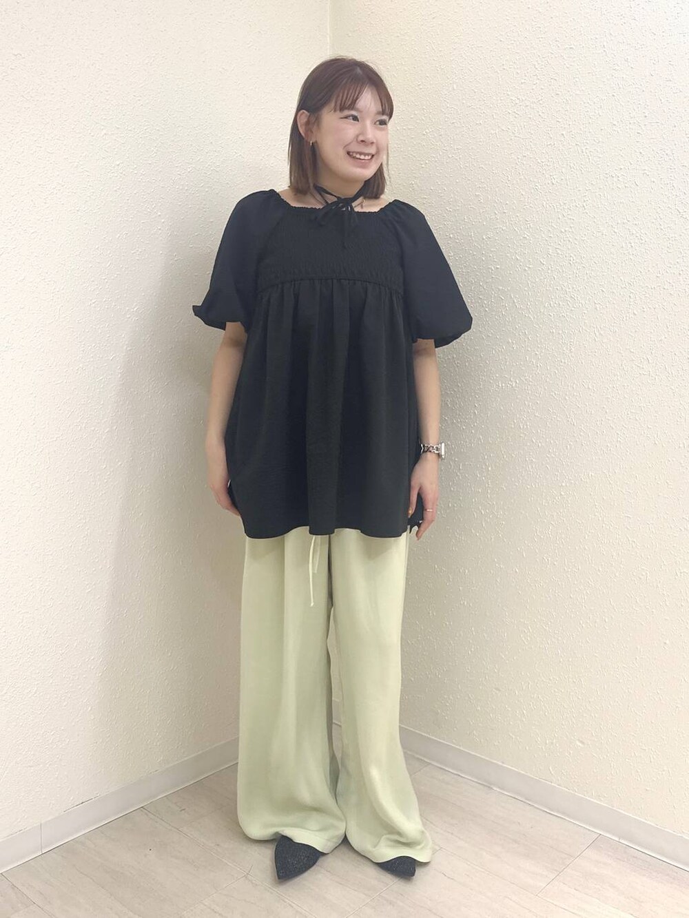 ブラック系のパンプス、グリーン系のその他パンツ、ブラック系のシャツ/ブラウスを着用したレディースの春コーディネートの2枚目の写真