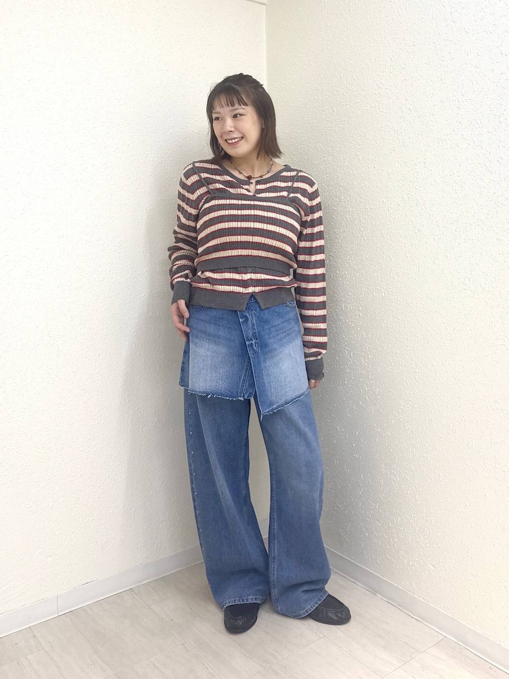 ブルー系のデニムパンツ、ブラック系のローファー、ブルー系のデニムパンツを着用したレディースの秋コーディネートの2枚目の写真