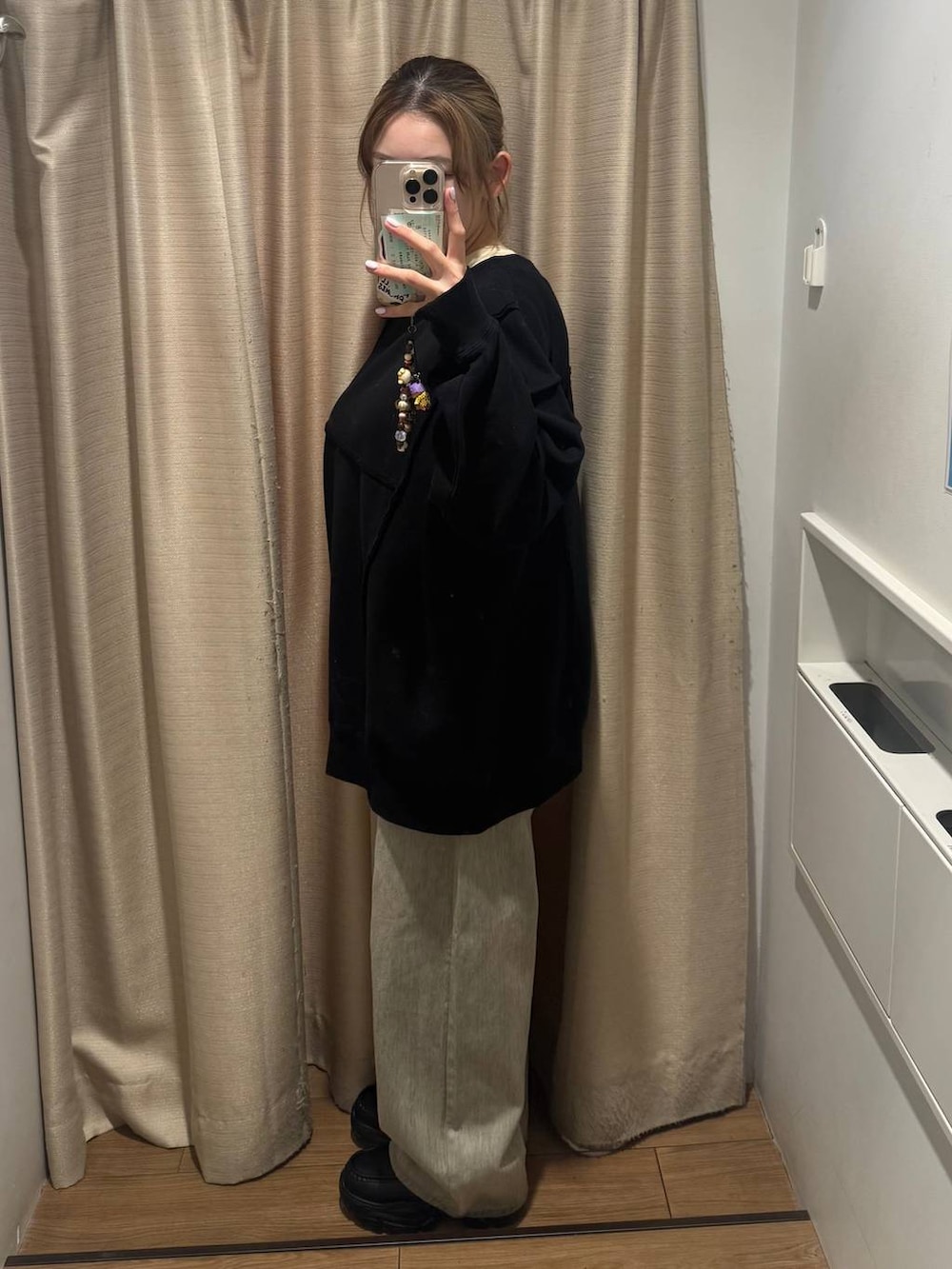 ブラック系のスウェット、イエロー系のTシャツ/カットソー、ベージュ系のデニムパンツを着用したレディースの冬コーディネートの2枚目の写真