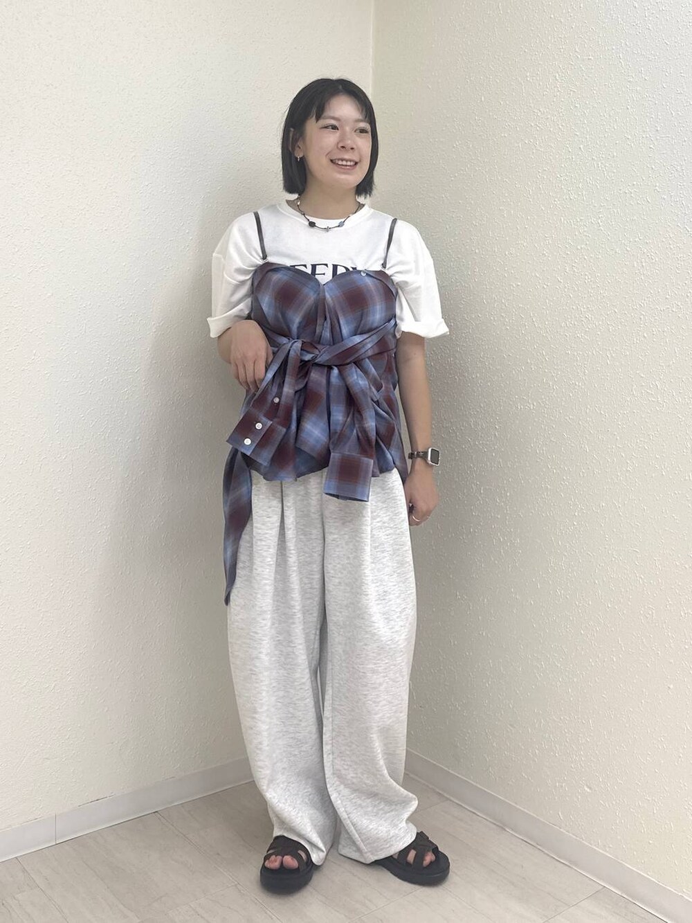 ホワイト系のTシャツ/カットソー、グレー系のスウェットパンツ、ブラウン系のサンダルを着用したレディースの夏コーディネートの2枚目の写真