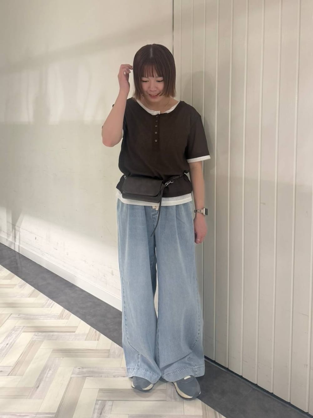 ブルー系のデニムパンツ、ブラウン系のTシャツ/カットソー、ブラウン系のボディバッグ/ウエストポーチを着用したレディースの春コーディネートの2枚目の写真