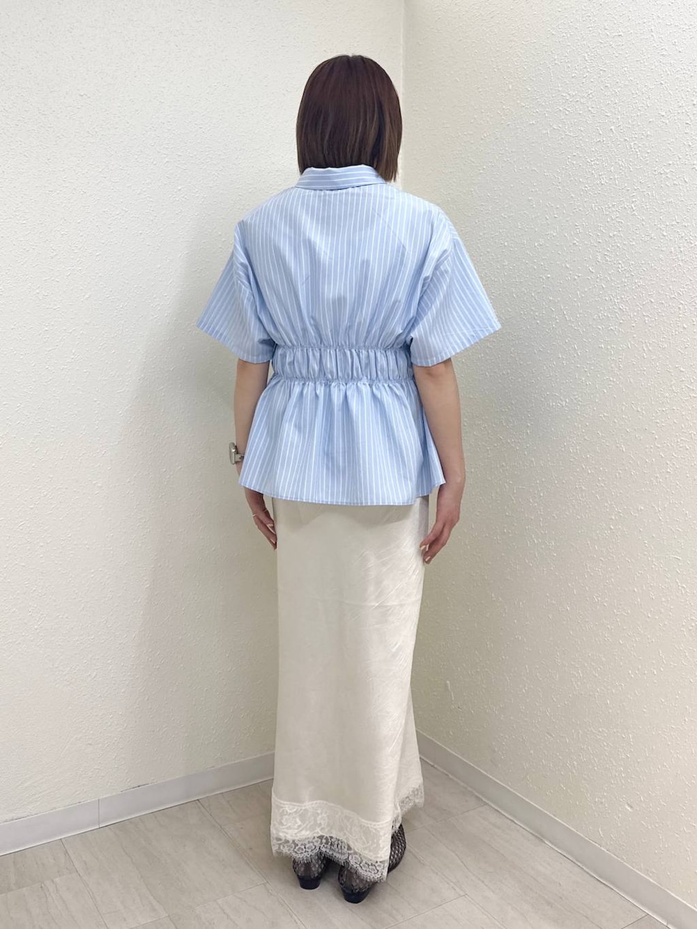 シルバー系のその他シューズ、ブルー系のTシャツ/カットソー、ホワイト系のスカートを着用したレディースの春コーディネートの4枚目の写真