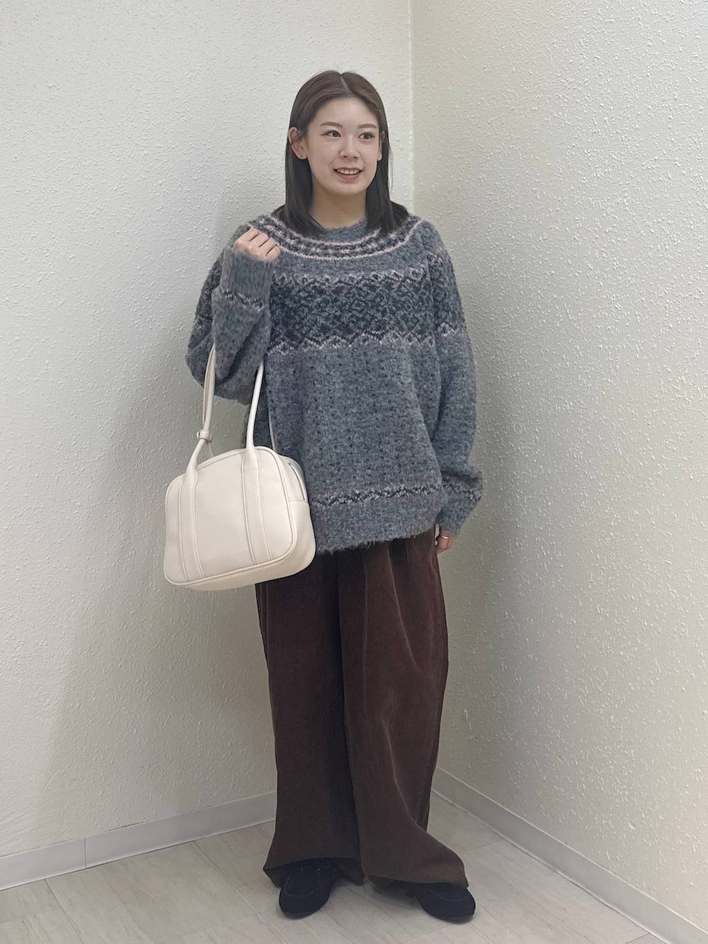 ブラウン系のその他パンツ、ブラック系のモカシン/デッキシューズ、ホワイト系のボストンバッグを着用したレディースの冬コーディネートの2枚目の写真