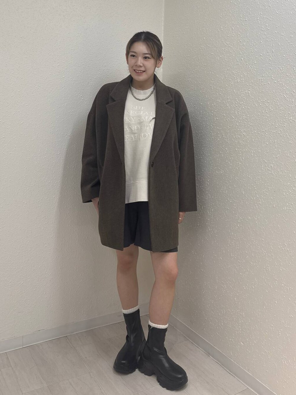 ブラック系のブーツ、ブラウン系のその他アウター、グレー系のその他パンツを着用したレディースの冬コーディネートの2枚目の写真