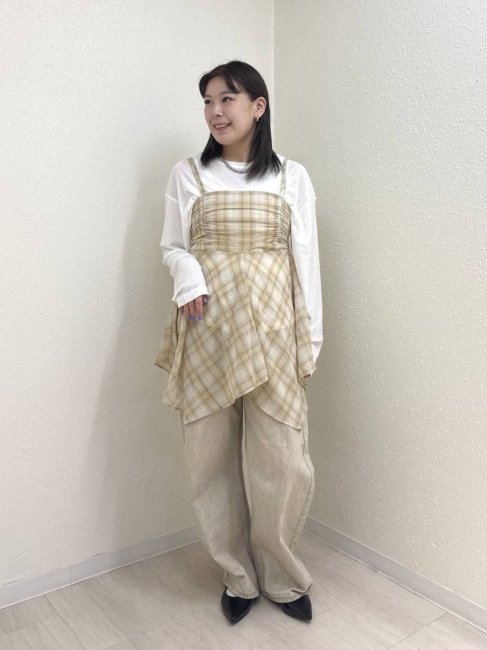 ホワイト系のTシャツ/カットソー、ブラック系のパンプス、ベージュ系のデニムパンツを着用したレディースの春コーディネートの2枚目の写真