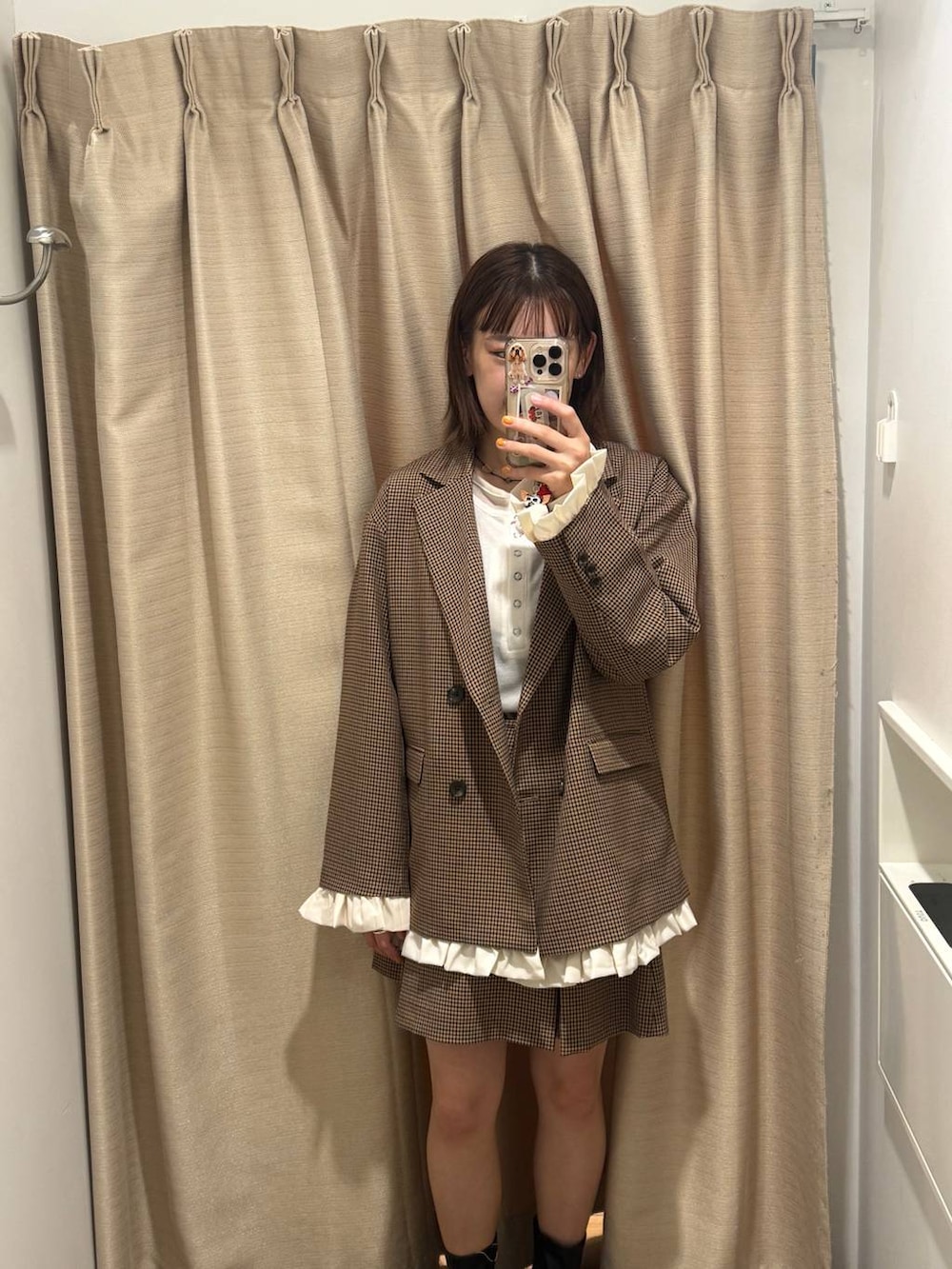 ブラック系のブーツ、ホワイト系のTシャツ/カットソー、ブラウン系のテーラードジャケットを着用したレディースの秋コーディネートの2枚目の写真