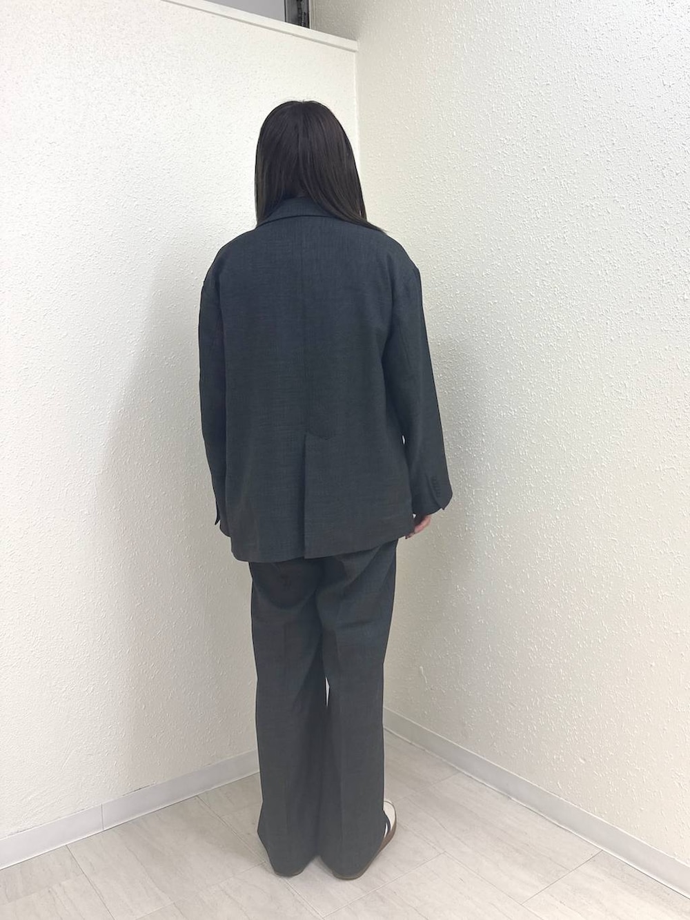 グレー系のテーラードジャケット、グレー系のデニムパンツ、ホワイト系のTシャツ/カットソーを着用したレディースの春コーディネートの3枚目の写真