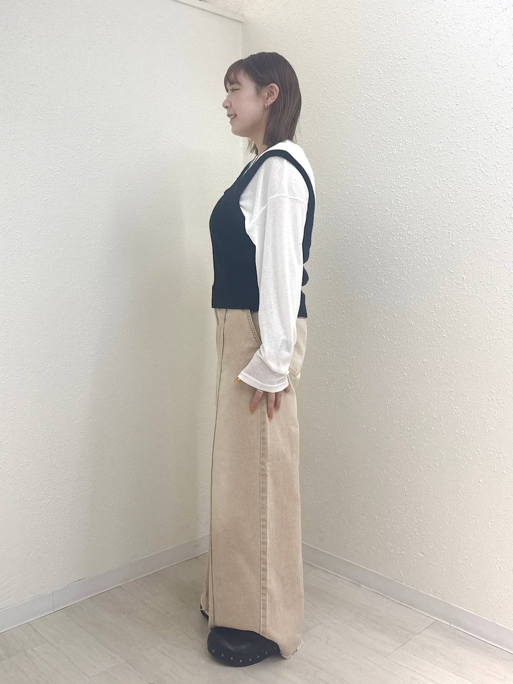 ホワイト系のTシャツ/カットソー、オレンジ系のデニムパンツ、ブラック系のサンダルを着用したレディースの春コーディネートの3枚目の写真