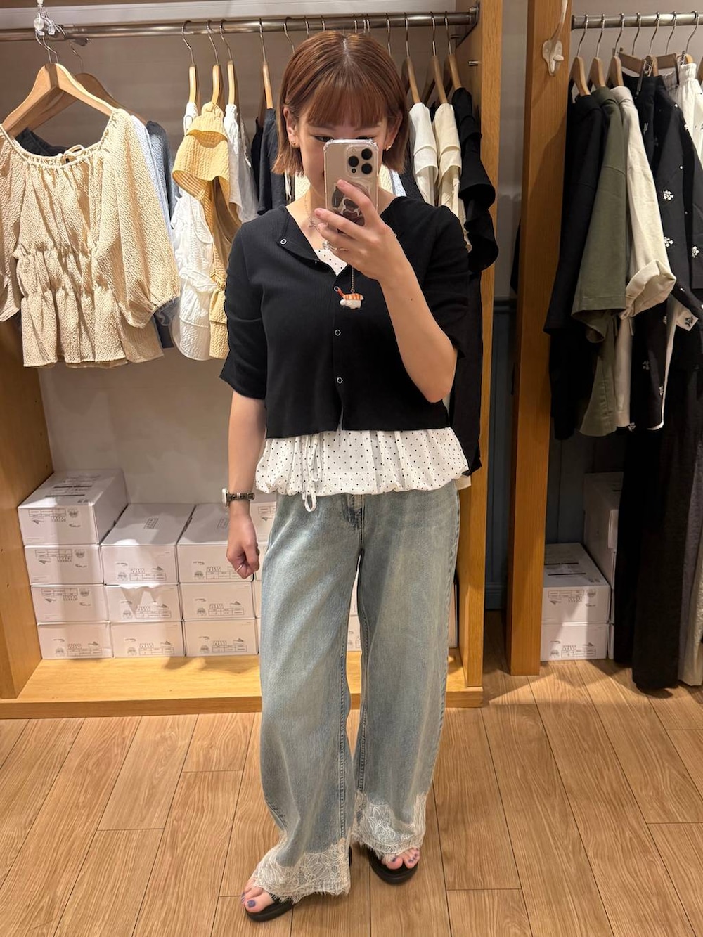 ブルー系のデニムパンツ、ブラック系のTシャツ/カットソー、ホワイト系のキャミソールを着用したレディースの夏コーディネートの2枚目の写真