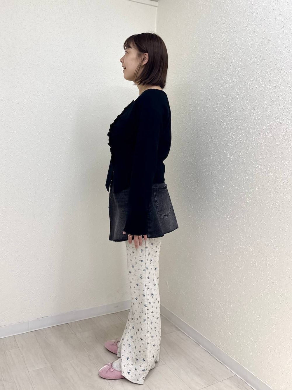 ブラック系のデニムパンツ、ピンク系のバレエシューズ、ブラック系のニット/セーターを着用したレディースの秋コーディネートの3枚目の写真