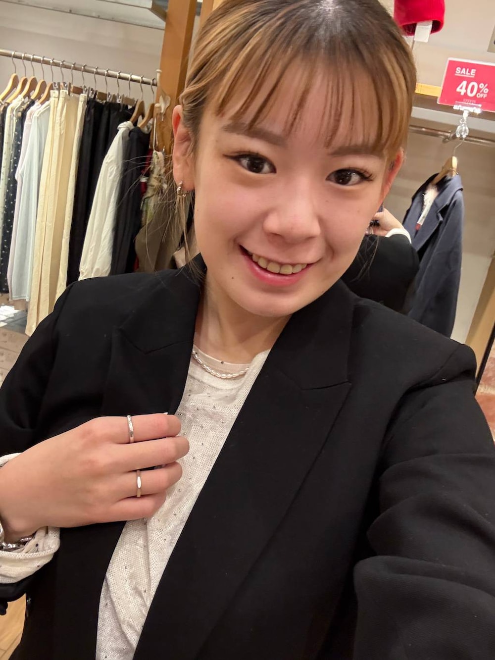 ホワイト系のスカート、ブラック系のテーラードジャケット、ホワイト系のTシャツ/カットソーを着用したレディースの冬コーディネートの2枚目の写真